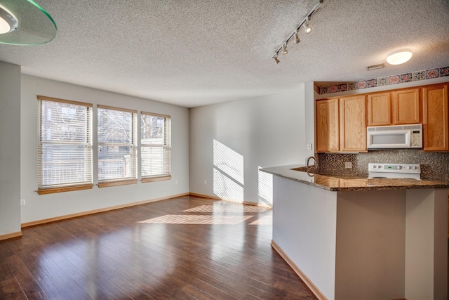 kitchen featuring a textured ceiling, dark hardwood / wood-style flooring, and white appliances