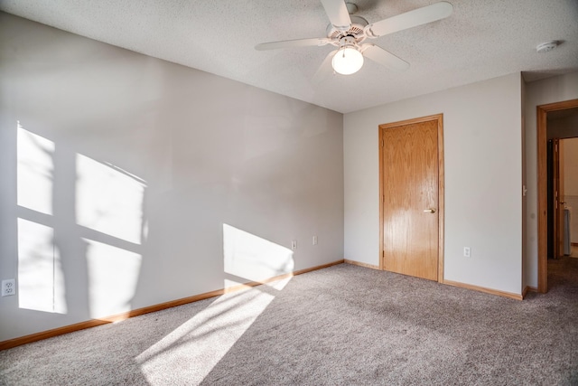 carpeted empty room with ceiling fan and a textured ceiling