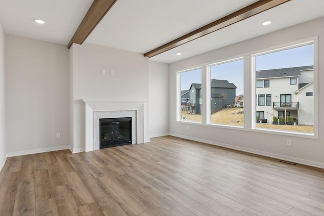 11459 Blazingstar Ln, Lake Elmo, MN 55042 - unfurnished living room with beamed ceiling, wood finished floors, a glass covered fireplace, baseboards, and recessed lighting
