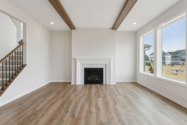 11459 Blazingstar Ln, Lake Elmo, MN 55042 - unfurnished living room featuring light wood-style flooring, beam ceiling, stairs, baseboards, and a fireplace