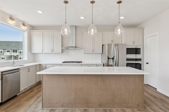 11459 Blazingstar Ln, Lake Elmo, MN 55042 - kitchen featuring stainless steel appliances, wall chimney range hood, a sink, a center island, and decorative backsplash