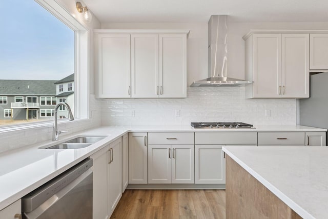 11459 Blazingstar Ln, Lake Elmo, MN 55042 - kitchen with appliances with stainless steel finishes, wall chimney range hood, a sink, and light countertops