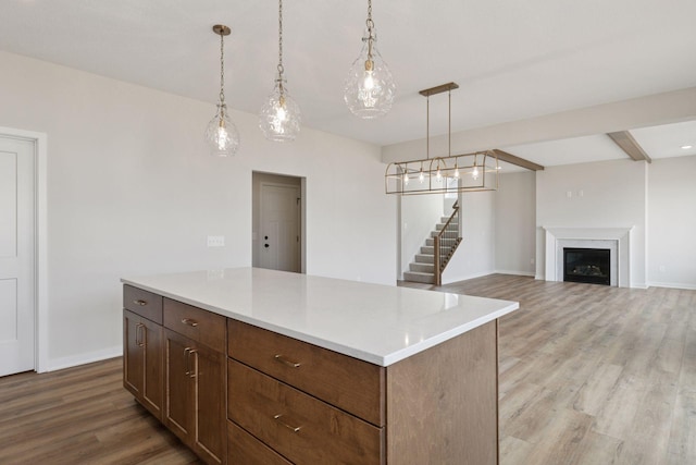11459 Blazingstar Ln, Lake Elmo, MN 55042 - kitchen with light wood-style flooring, light countertops, hanging light fixtures, baseboards, and a fireplace