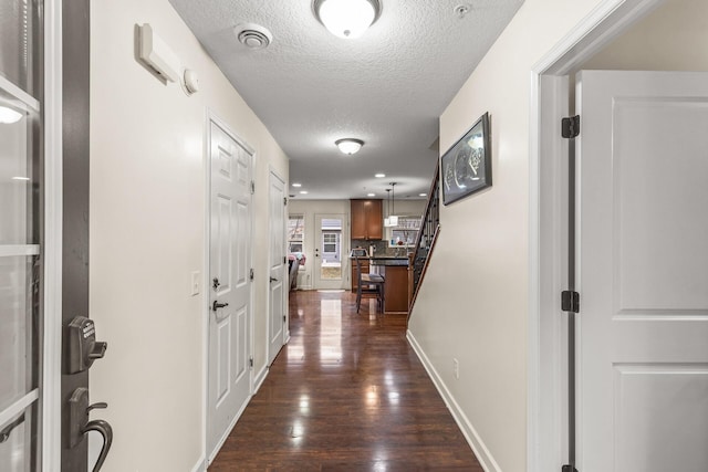 hallway featuring dark hardwood / wood-style floors and a textured ceiling