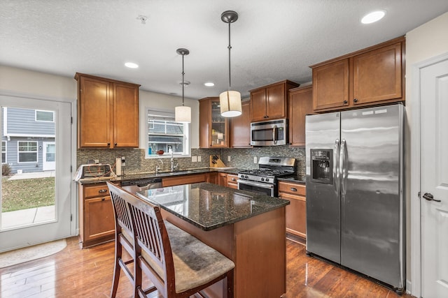 kitchen featuring sink, a kitchen island, dark hardwood / wood-style floors, and appliances with stainless steel finishes