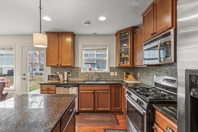 kitchen featuring a healthy amount of sunlight, sink, hanging light fixtures, and appliances with stainless steel finishes