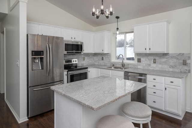 kitchen featuring a center island, sink, decorative light fixtures, white cabinetry, and stainless steel appliances