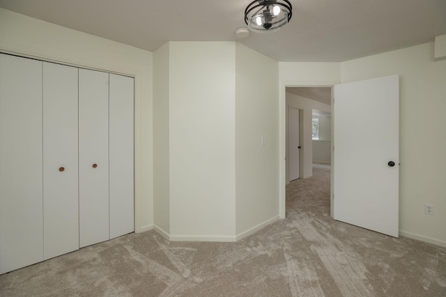 unfurnished bedroom with light carpet and a closet