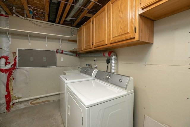 laundry room with separate washer and dryer and cabinets