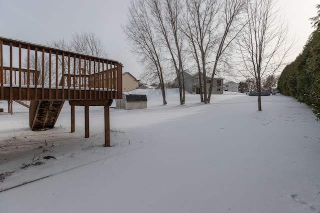 snowy yard featuring a deck