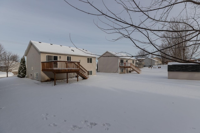 snow covered house featuring a deck