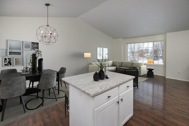 kitchen with a center island, white cabinets, hanging light fixtures, vaulted ceiling, and dark hardwood / wood-style flooring