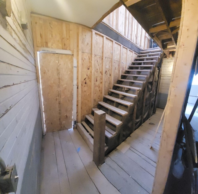 stairway with hardwood / wood-style flooring and wooden walls