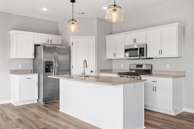 kitchen featuring pendant lighting, white cabinets, and appliances with stainless steel finishes