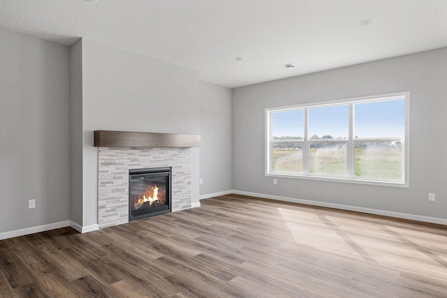 unfurnished living room with wood-type flooring and a fireplace