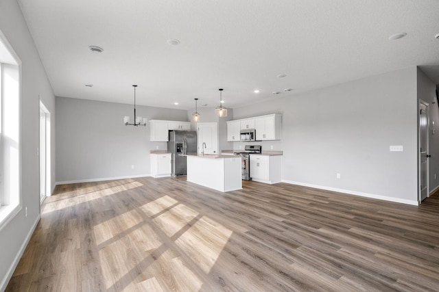 unfurnished living room with hardwood / wood-style flooring, a chandelier, and sink