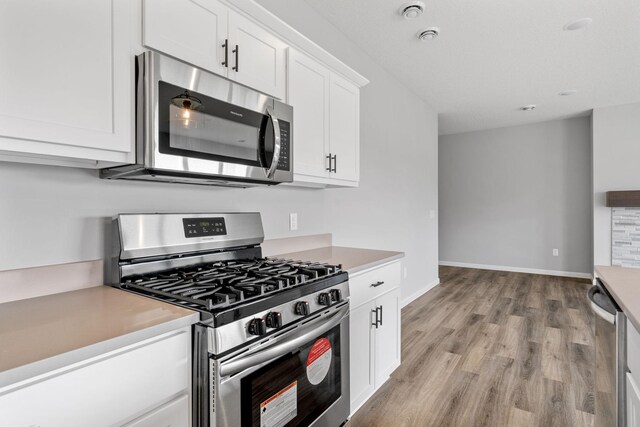 kitchen featuring white cabinetry, appliances with stainless steel finishes, and light wood-type flooring