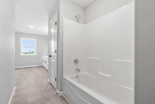 bathroom with tile patterned flooring, vanity, and  shower combination