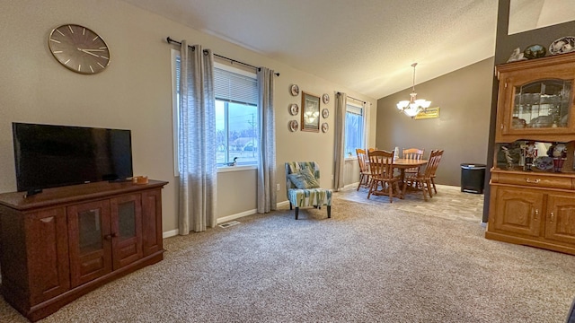 living area featuring vaulted ceiling, light colored carpet, and a chandelier