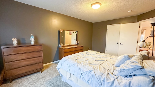 carpeted bedroom with a textured ceiling and a closet