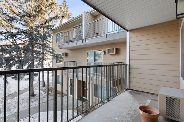 snow covered back of property featuring a wall mounted AC