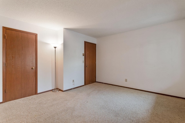 carpeted empty room featuring a textured ceiling