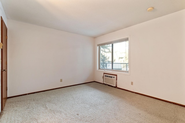 carpeted spare room featuring a wall unit AC