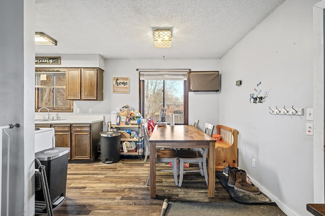 dining room featuring sink, dark hardwood / wood-style flooring, and a textured ceiling