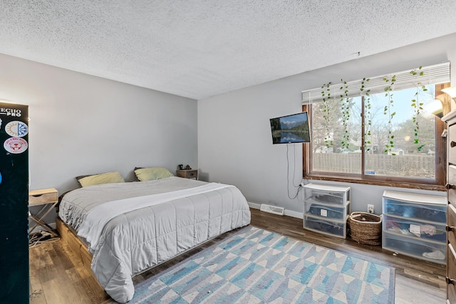 bedroom with hardwood / wood-style floors and a textured ceiling