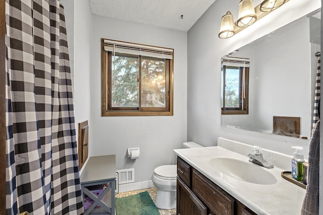 bathroom featuring tile patterned flooring, vanity, a textured ceiling, and toilet