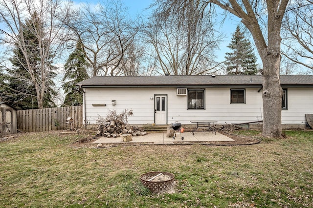 rear view of property with a fire pit, a wall mounted air conditioner, a yard, and a patio