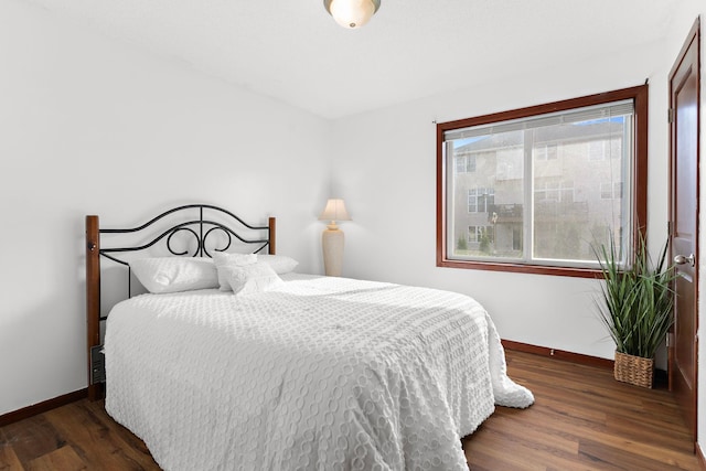 bedroom with dark hardwood / wood-style flooring