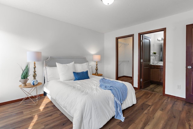 bedroom featuring a walk in closet, ensuite bathroom, a closet, and dark hardwood / wood-style floors