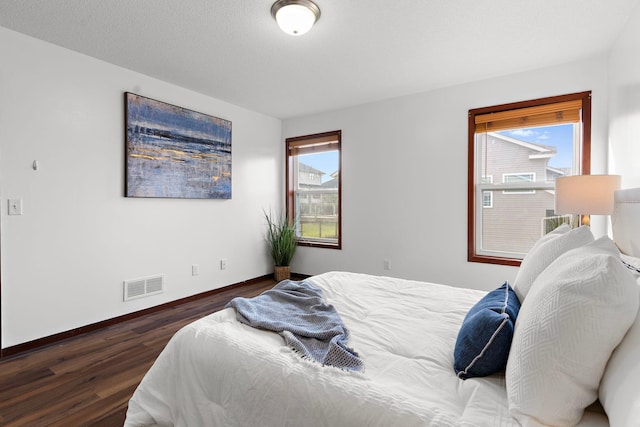 bedroom featuring dark hardwood / wood-style flooring and multiple windows