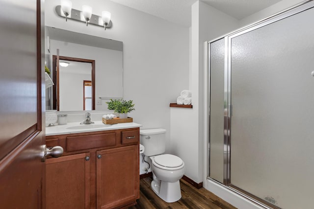 bathroom with wood-type flooring, vanity, toilet, and walk in shower