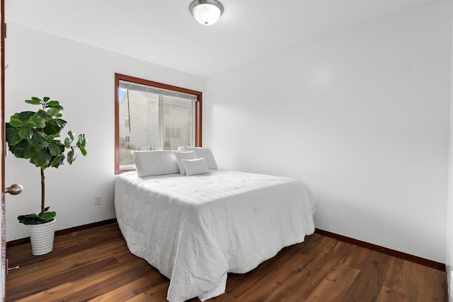 bedroom with dark hardwood / wood-style floors