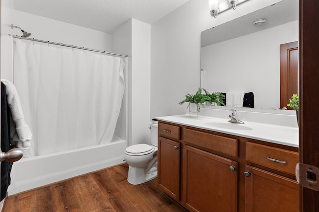 full bathroom featuring a textured ceiling, toilet, shower / tub combo with curtain, vanity, and hardwood / wood-style flooring