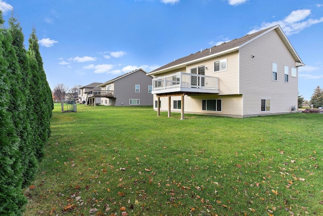 rear view of house featuring a deck and a yard