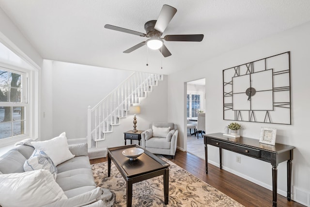 living room featuring a textured ceiling, dark hardwood / wood-style floors, and ceiling fan