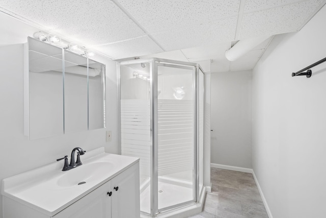 bathroom featuring a paneled ceiling, vanity, and an enclosed shower