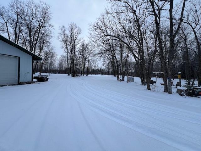 snowy yard with an outdoor structure and a garage