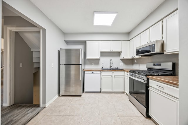 kitchen featuring light wood-type flooring, white cabinetry, sink, and appliances with stainless steel finishes