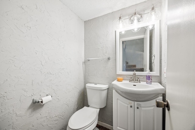 bathroom featuring vanity, a textured ceiling, and toilet