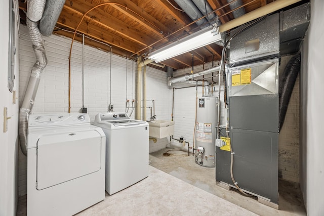 laundry room featuring heating unit, separate washer and dryer, brick wall, and water heater