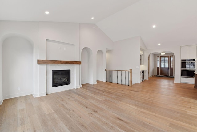 unfurnished living room with light hardwood / wood-style flooring and high vaulted ceiling