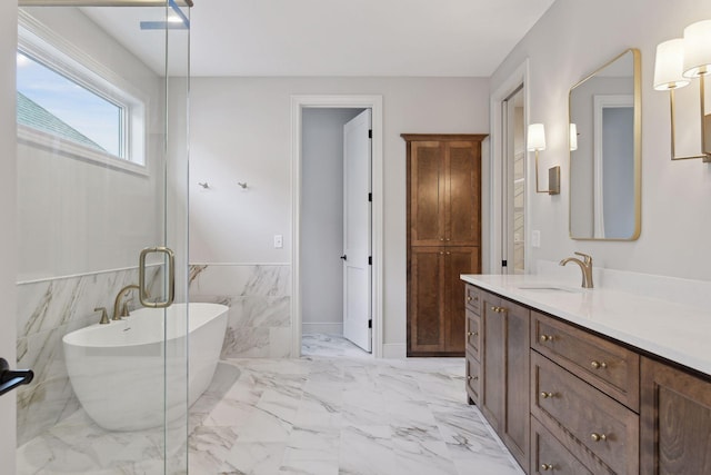 bathroom featuring a washtub, vanity, and tile walls