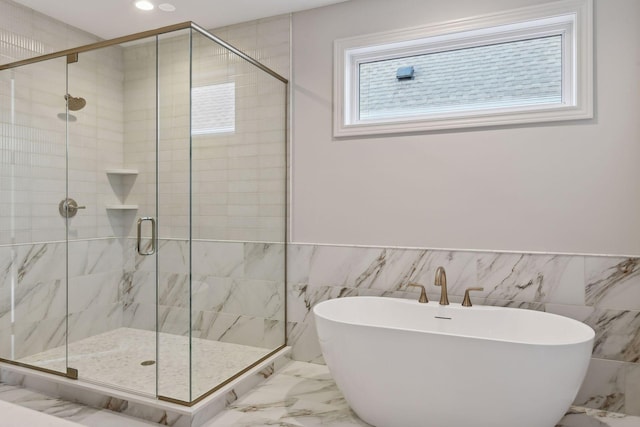 bathroom featuring tile walls and shower with separate bathtub