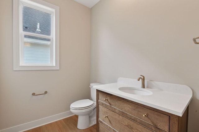 bathroom with vanity, toilet, and wood-type flooring