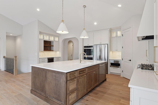 kitchen with tasteful backsplash, premium range hood, vaulted ceiling, light hardwood / wood-style flooring, and white cabinetry