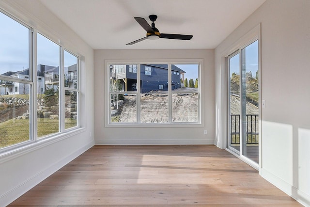 unfurnished sunroom with ceiling fan